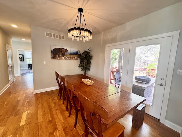 dining room with visible vents, wood finished floors, baseboards, an inviting chandelier, and recessed lighting