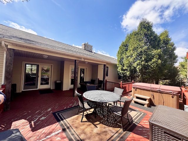 deck featuring outdoor dining space and a hot tub
