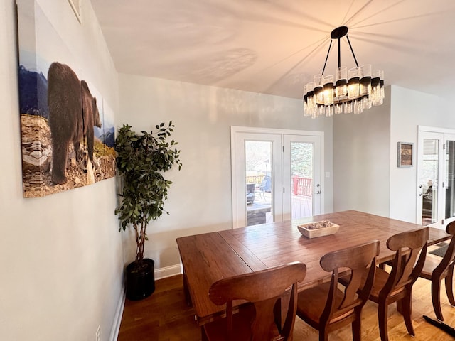 dining area featuring french doors, baseboards, a notable chandelier, and wood finished floors