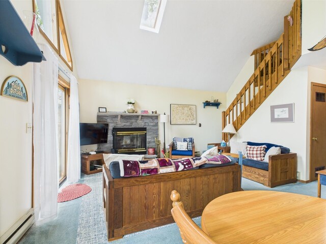 199 Wyomissing Dr, Pocono Lake, PA 18347 - carpeted living area featuring a baseboard radiator, stairway, a stone fireplace, a skylight, and vaulted ceiling