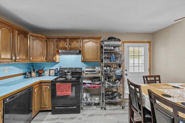 2726 Pocono Cir, Bartonsville, PA 18321 - kitchen with black appliances, under cabinet range hood, light wood-style flooring, light countertops, and brown cabinets