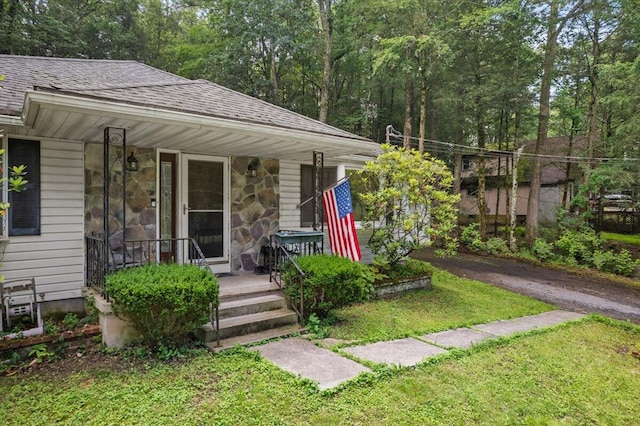 2726 Pocono Cir, Bartonsville, PA 18321 - view of front of house featuring covered porch, stone siding, roof with shingles, and a front lawn