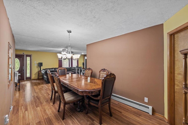 2726 Pocono Cir, Bartonsville, PA 18321 - dining area featuring baseboard heating, wood finished floors, a chandelier, and a textured ceiling