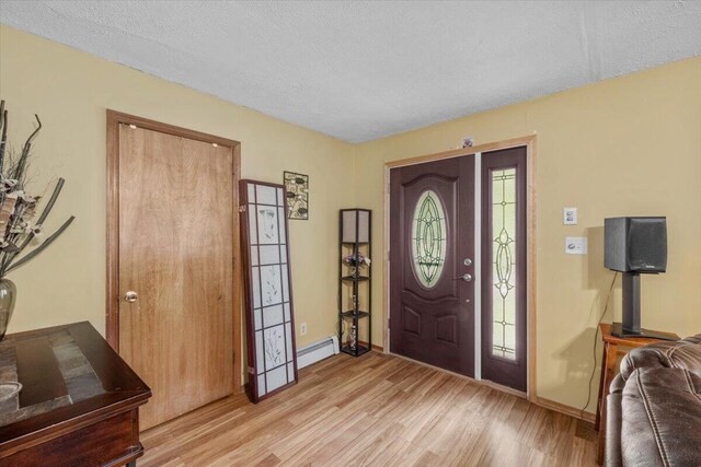 2726 Pocono Cir, Bartonsville, PA 18321 - entrance foyer with light wood-style flooring, a textured ceiling, and a baseboard radiator