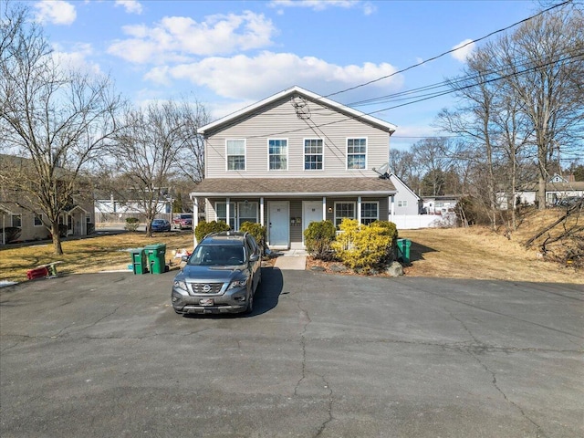 traditional home featuring a porch and roof with shingles