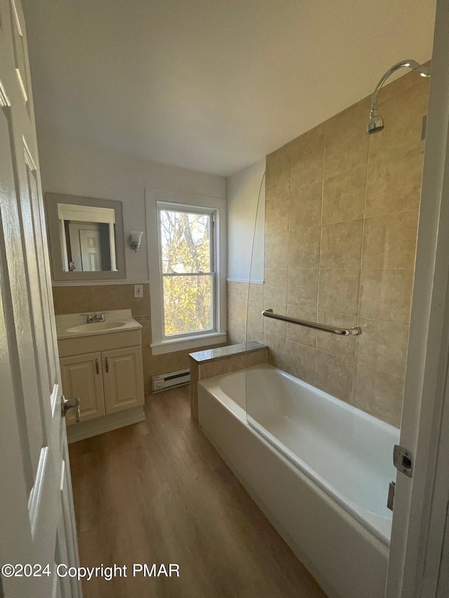 bathroom with a shower, a bathing tub, a baseboard radiator, vanity, and tile walls