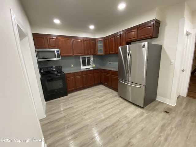 kitchen with stainless steel appliances, recessed lighting, a sink, and light wood-style floors