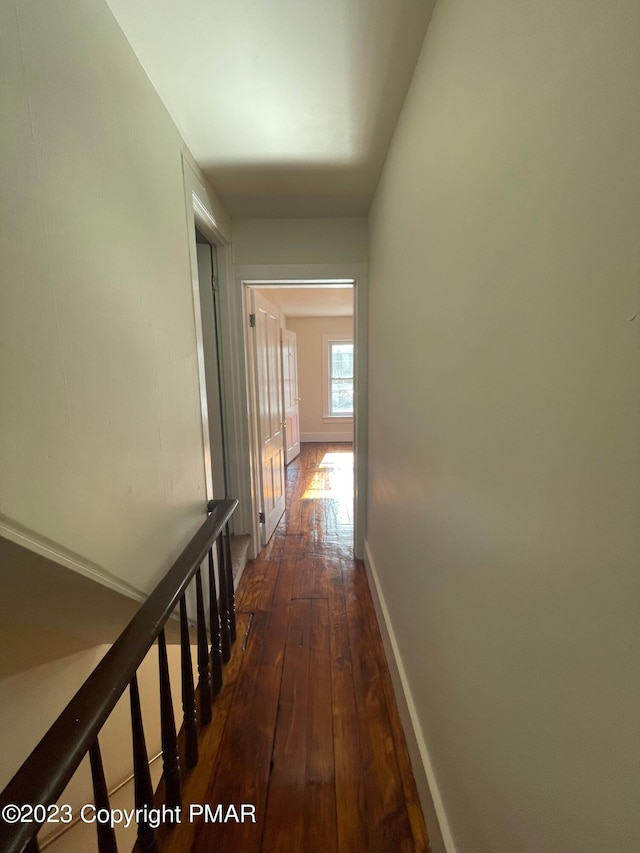 hallway with dark wood finished floors and baseboards