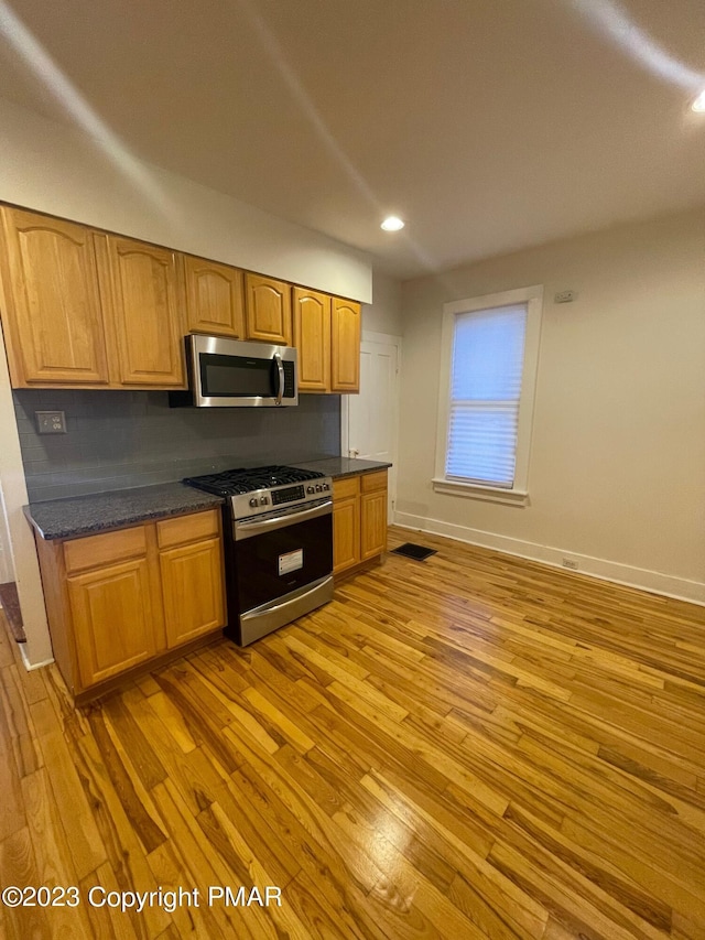 kitchen with visible vents, baseboards, light wood-style flooring, stainless steel appliances, and recessed lighting