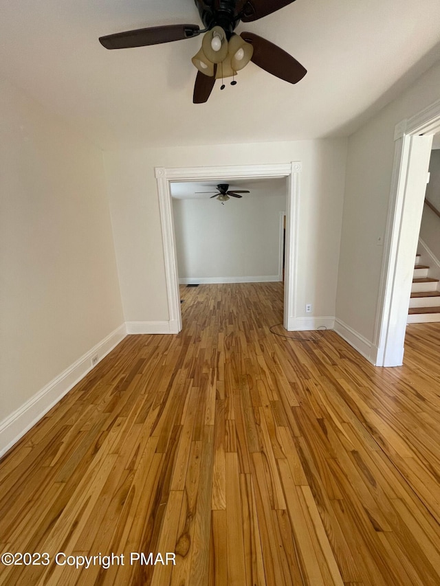 empty room featuring stairway, wood finished floors, and baseboards