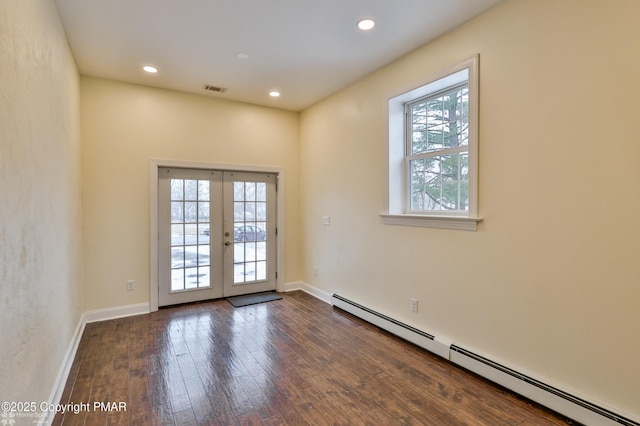 empty room featuring visible vents, a baseboard heating unit, recessed lighting, french doors, and wood-type flooring