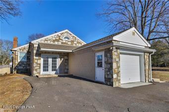 view of front of home with aphalt driveway, french doors, and a garage
