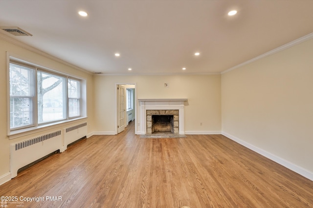 unfurnished living room featuring crown molding, radiator, visible vents, and light wood finished floors