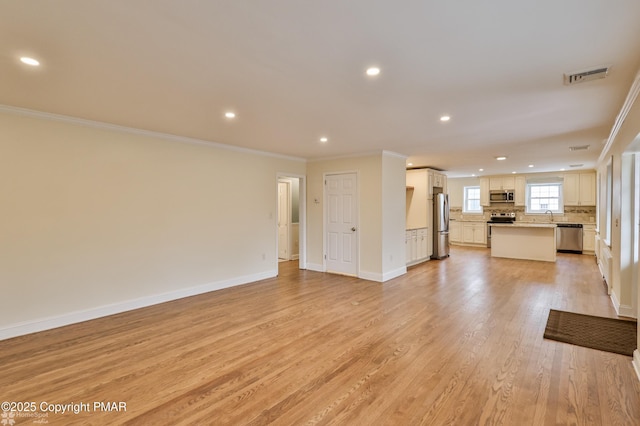 unfurnished living room with visible vents, baseboards, crown molding, and light wood-style floors