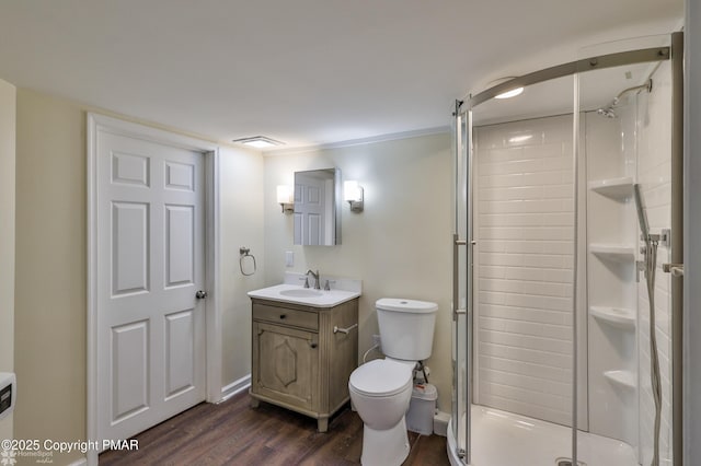 full bath with vanity, toilet, wood finished floors, and a stall shower