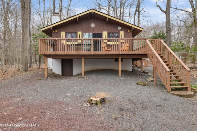 exterior space with a deck, a chimney, and stairway