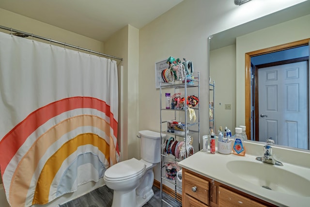 bathroom with vanity, wood finished floors, toilet, and a shower with curtain