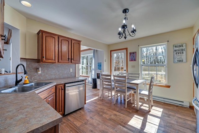 kitchen with dark wood finished floors, a sink, decorative backsplash, and stainless steel dishwasher