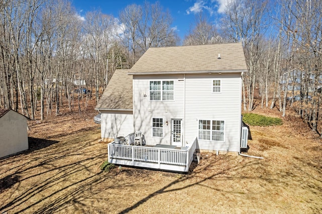 rear view of house featuring a deck and a shingled roof