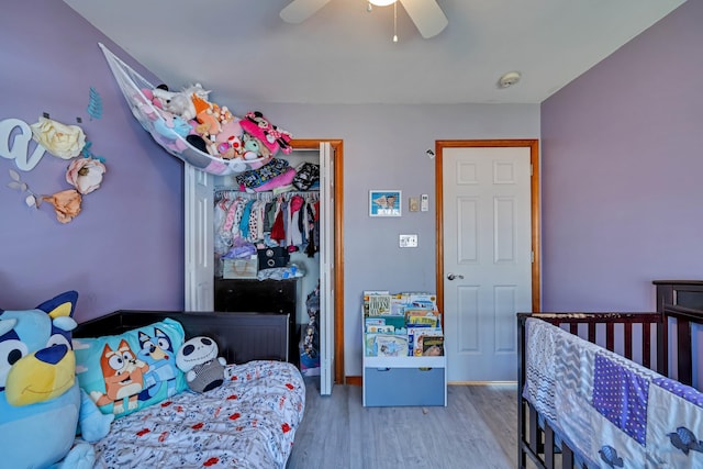 bedroom featuring a ceiling fan, wood finished floors, baseboards, and a closet