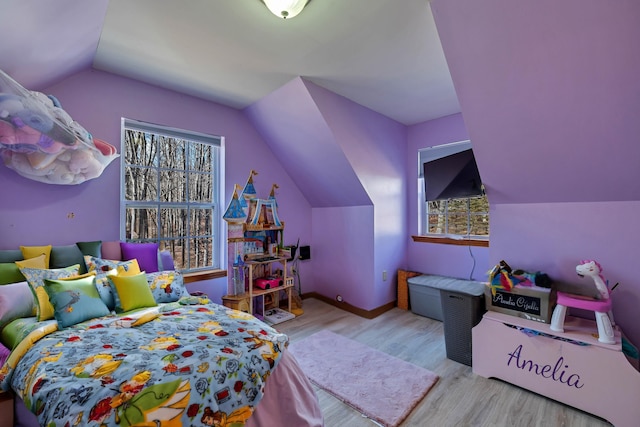 bedroom with baseboards, lofted ceiling, and wood finished floors