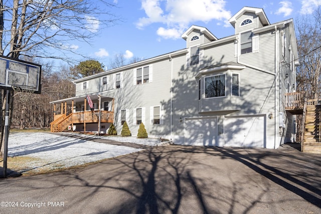 view of front facade featuring a garage, stairs, and aphalt driveway