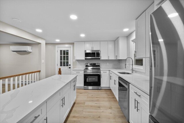 173 Water View Dr, Hawley, PA 18428 - kitchen with appliances with stainless steel finishes, a wall mounted air conditioner, white cabinetry, and recessed lighting