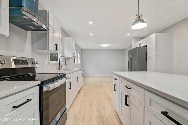 kitchen with wall chimney exhaust hood, stainless steel appliances, a sink, and light countertops