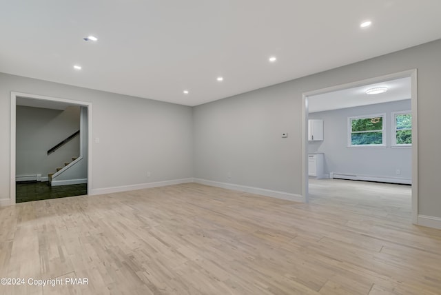 unfurnished room featuring light wood-style flooring, a baseboard heating unit, baseboard heating, and recessed lighting