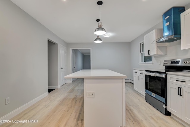 kitchen featuring light countertops, light wood-style flooring, electric range, a kitchen island, and wall chimney exhaust hood