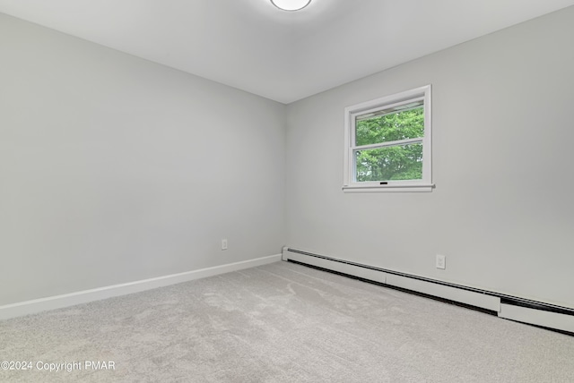 carpeted spare room with a baseboard radiator and baseboards