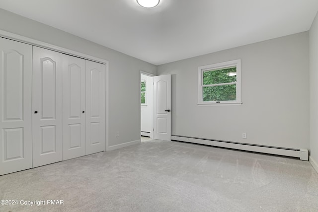 unfurnished bedroom with multiple windows, a baseboard radiator, and carpet flooring