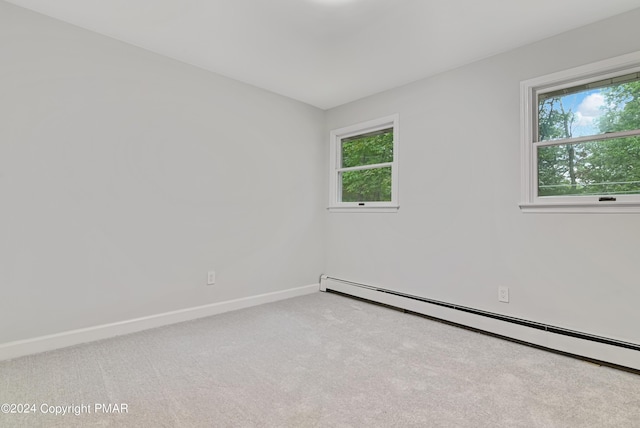 empty room with a healthy amount of sunlight, carpet flooring, baseboards, and baseboard heating