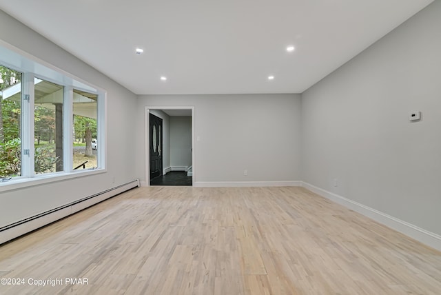 empty room featuring baseboards, a baseboard radiator, light wood-style flooring, baseboard heating, and recessed lighting