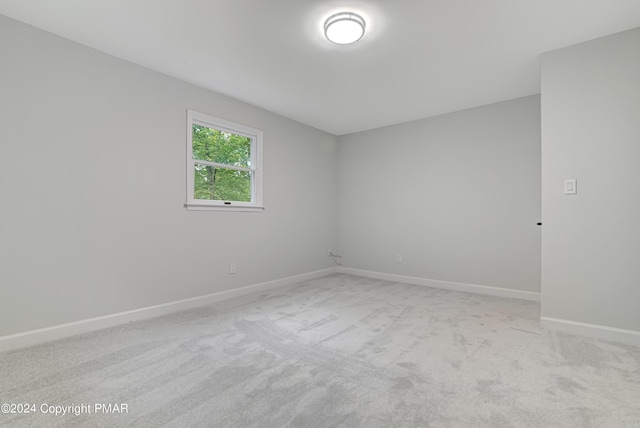 unfurnished room with light carpet and baseboards