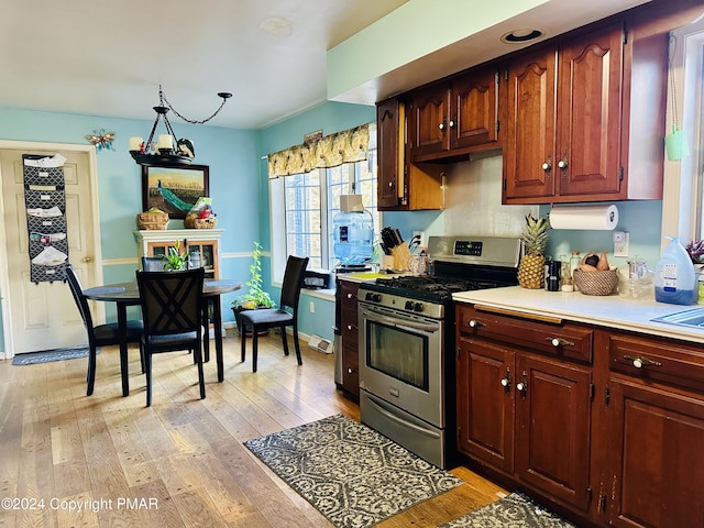 kitchen featuring stainless steel gas stove, light countertops, and light wood-type flooring