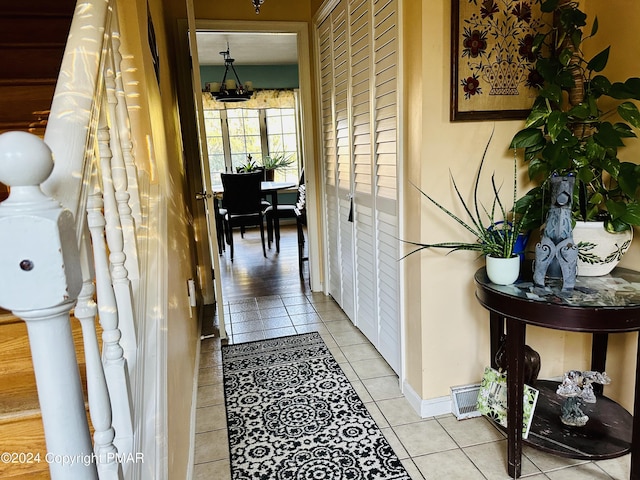 hallway with light tile patterned flooring and baseboards