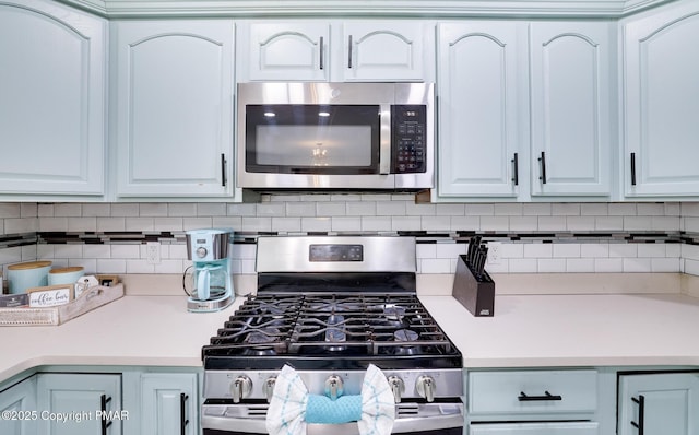 kitchen featuring backsplash, stainless steel appliances, and white cabinets