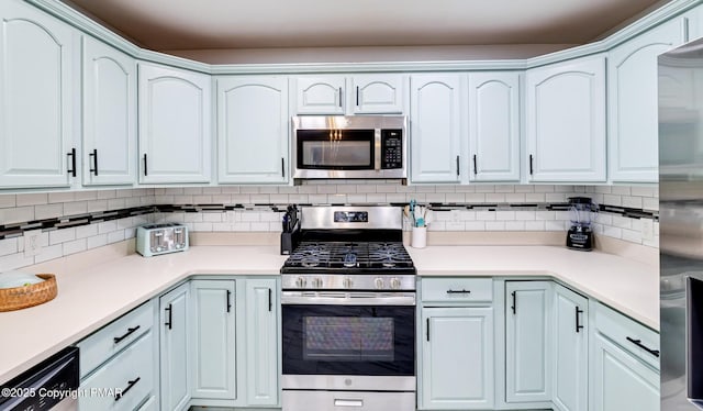 kitchen with stainless steel appliances, light countertops, and decorative backsplash