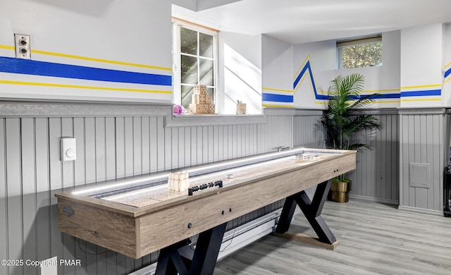 recreation room with wainscoting and wood finished floors