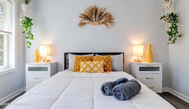 bedroom with dark wood-style floors and baseboards