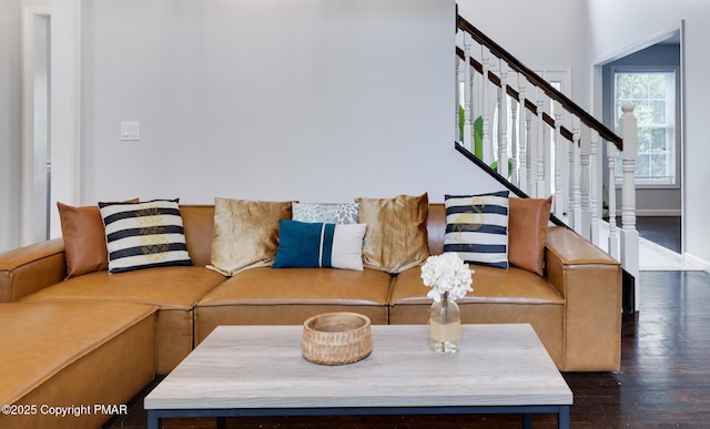 living room featuring stairs, baseboards, and wood finished floors