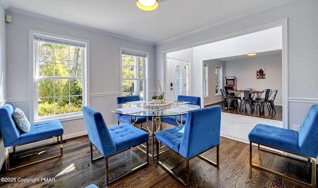 dining area featuring baseboards, wood finished floors, and crown molding