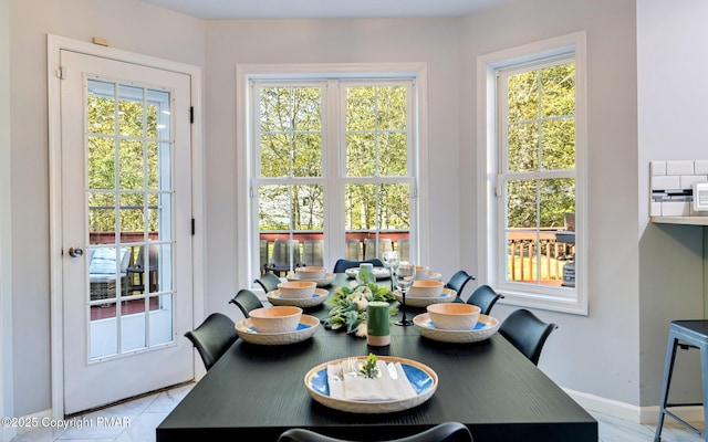 dining room featuring a healthy amount of sunlight and baseboards