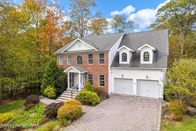 view of front of house with a garage, decorative driveway, brick siding, and a shingled roof