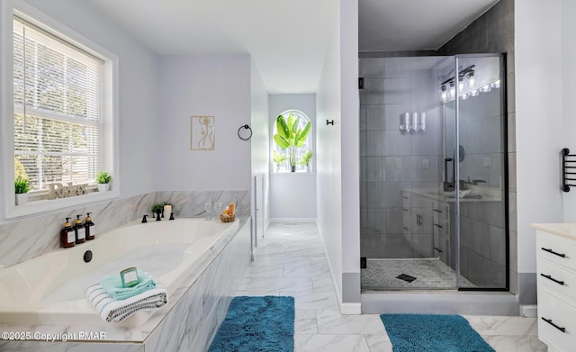 full bathroom featuring marble finish floor, plenty of natural light, a shower stall, and a bath