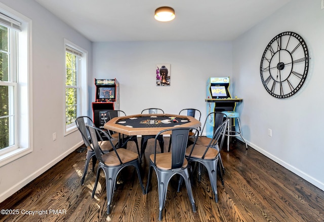 dining space featuring dark wood-type flooring and baseboards