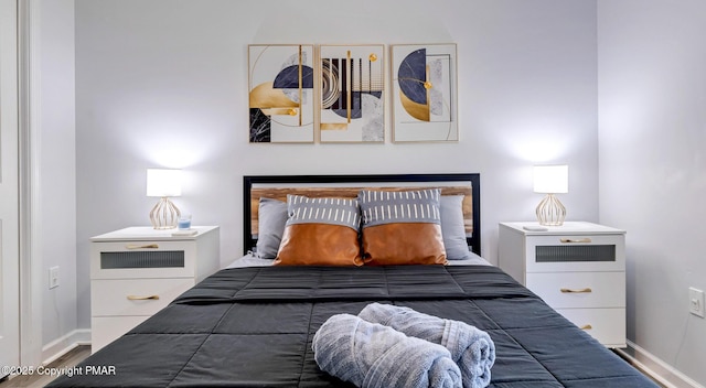 bedroom with baseboards and wood finished floors