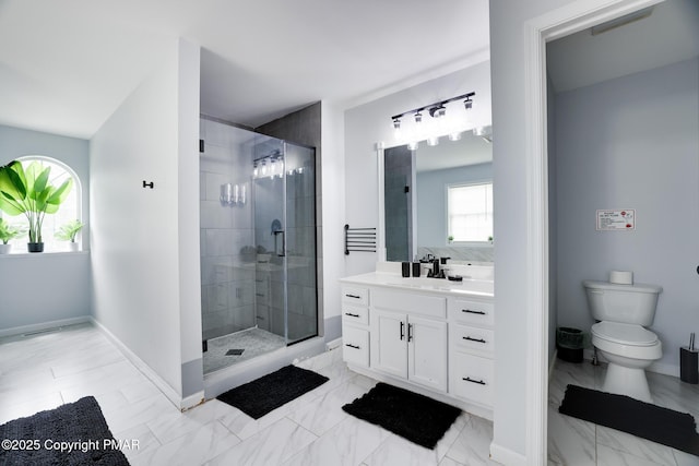 bathroom with vanity, plenty of natural light, a shower with shower door, and toilet