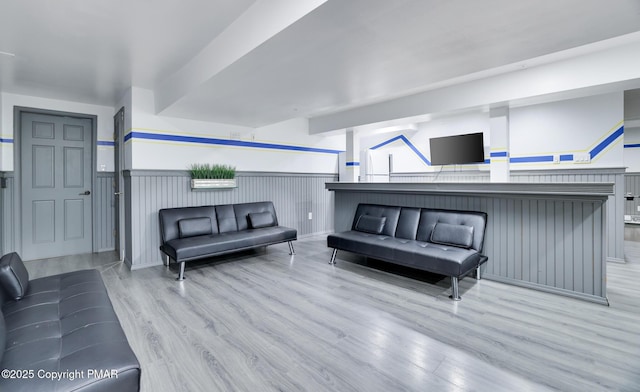 living area featuring wainscoting and wood finished floors